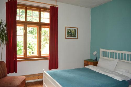 a bedroom with a bed and a window with red curtains at Herberge Vitopia in Magdeburg