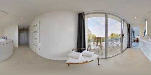 a living room with a large white room with a large window at Les Digues Vauban in Ciboure