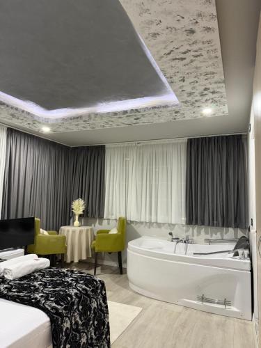 ein Schlafzimmer mit Badewanne, Bett und Tisch in der Unterkunft Hotel Fantazia in Shkodra