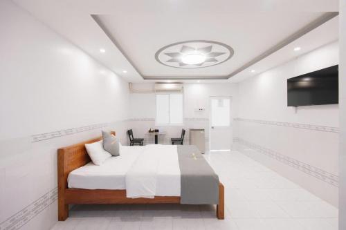 a white room with a bed and a television at Hotel TRUNG LÀI in Tây Ninh