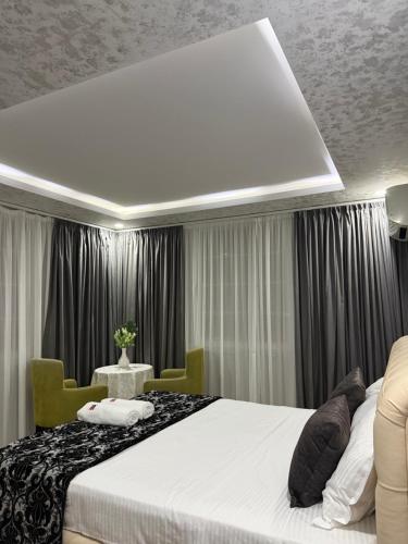 ein Schlafzimmer mit einem Bett und einem Tisch mit Stühlen in der Unterkunft Hotel Fantazia in Shkodra