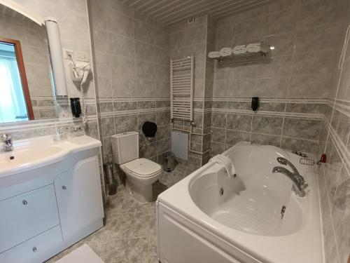 a bathroom with a tub and a toilet and a sink at Hotel Metropol – Metropol Lake Resort in Ohrid
