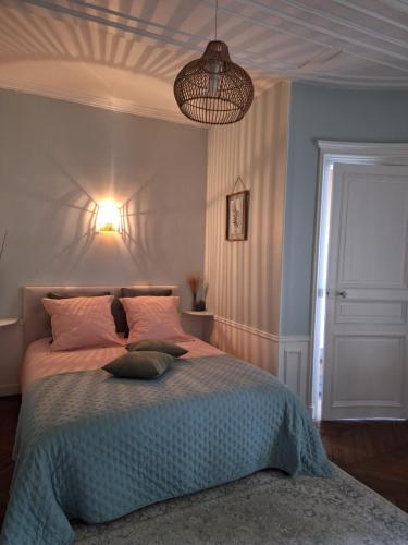 a bedroom with a large bed with a light fixture at Chambre d'hôtes du Château de Digeon in Morvillers-Saint-Saturnin