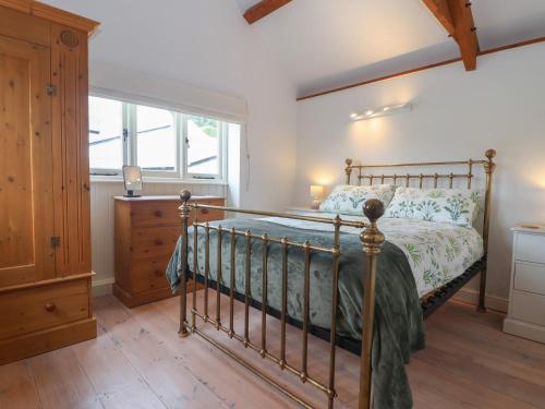 a bedroom with a bed and a dresser and a window at Wrens Nest in Kingsbridge