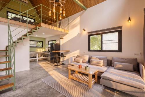 a living room with a couch and a staircase at Coco Nest in Ko Phangan