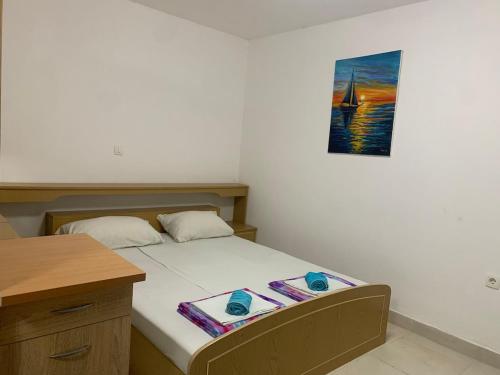 a bedroom with a bed with a picture on the wall at Vila Nikolic in Lastva