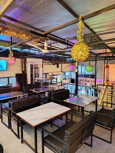 a restaurant with tables and chairs and a chandelier at Novo Axora Lounge & Accommodation Kimbo Ruiru Kimbo Lopha Stage in Ruiru