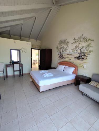a bedroom with a large bed and a couch at Hotel Theasis in Paralía Sergoúlas