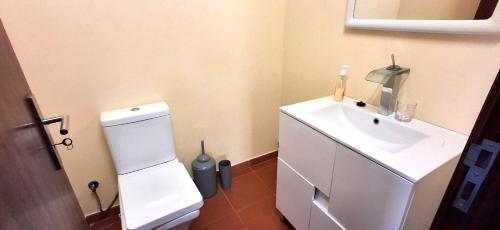 a bathroom with a white sink and a toilet at A Casa de Santana in Santana