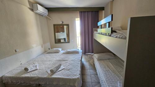 two twin beds in a room with a staircase at Sithonia Mare Hotel in Gerakini