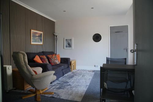 a living room with a couch and a chair at Seaford Snug in Seaford