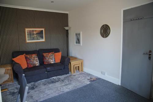 a living room with a blue couch and a table at Seaford Snug in Seaford