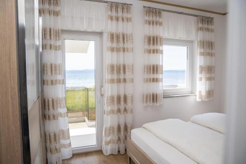 a bedroom with a bed and a window with a view at Beachfront Reiterer Villa V1 with Jacuzzi 30 meters from the Beach - CROWONDER LUXURY RENT in Privlaka