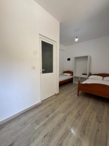 a white room with a bed and a door at City & Sea Hideout in Himare