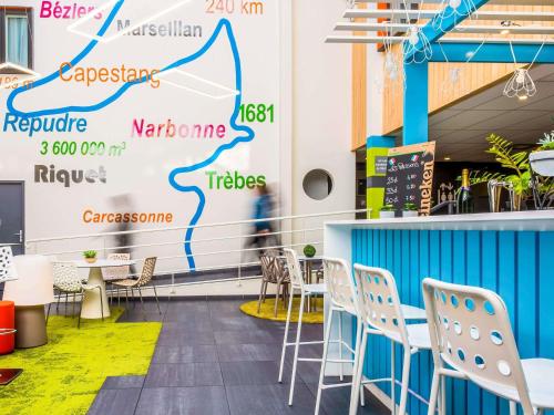 a room with chairs and a wall with a map at Ibis Styles Toulouse Labège in Labège