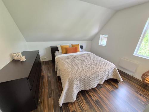 a bedroom with a bed with orange pillows on it at White Cat Guesthouse in Ålesund