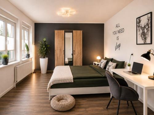 a bedroom with a bed and a desk with a laptop at Ferienwohnung Penny-Ranch in Zethau