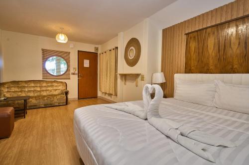 a bedroom with a large white bed and a couch at Baan Suan ChiChan บ้านสวนชีจรรย์ in Na Jomtien
