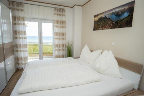 a white bedroom with a large bed and a window at Beachfront Reiterer Villa V3 with Jacuzzi 30 meters from the Beach - CROWONDER LUXURY RENT in Privlaka