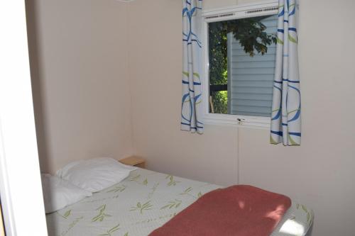 a bedroom with a bed and a window at Camping du Creulet in Crouay