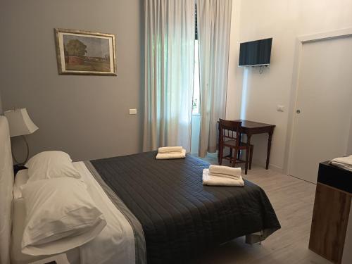 a bedroom with a bed with two towels on it at VillaGioveRooms in Prato