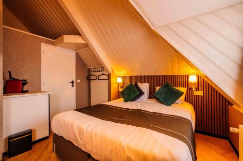 a bedroom with a large bed with green pillows at Hotel Buren in Buren