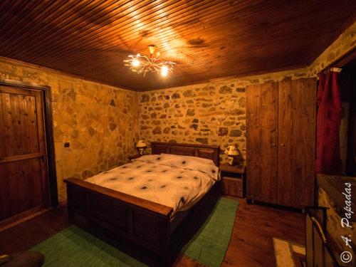 um quarto com uma cama num quarto com paredes de pedra em Al Monte Hotel em Vronterón