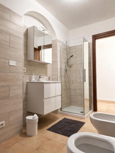 a bathroom with a shower and a sink and a toilet at ALLOGGIO CASA IN PIETRA in Santu Lussurgiu