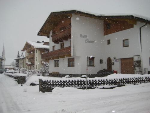 a large building covered in snow in a yard at Haus Christl in Uderns