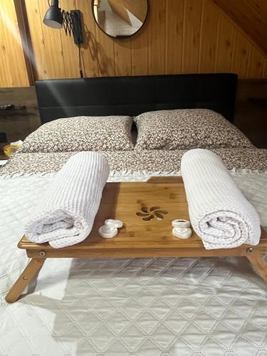 a bed with a wooden tray with towels on it at Agro Bieszczady 2 in Czarna