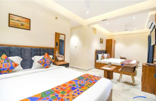 a hotel room with two beds and a desk at The Golden Plaza in Tarapith