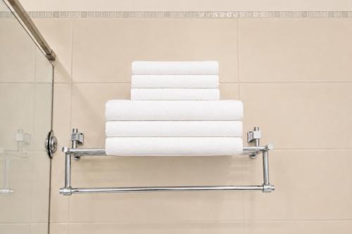 a stack of towels on a towel rack in a bathroom at Hotel Nartel in Prishtinë