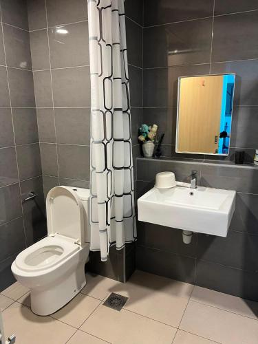 a bathroom with a toilet and a sink at Umi Studio Imperium Residence in Telok Baru