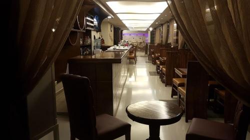 a restaurant with a bar and tables and chairs at hotel le noble in Beirut