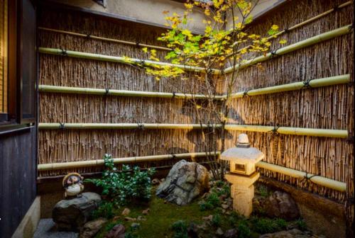 a garden with a fire hydrant in front of a fence at 京宿日和 聚楽 Hiyori Juraku in Kyoto