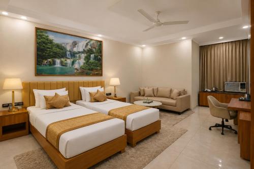ein Hotelzimmer mit zwei Betten und einem Schreibtisch in der Unterkunft Hotel Aero Stay Igi Delhi Airport in Neu-Delhi