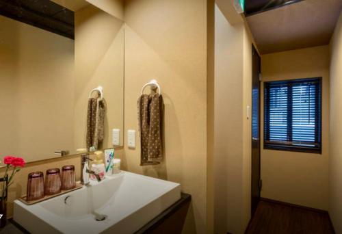 a bathroom with a white sink and a mirror at 京宿日和 聚楽 Hiyori Juraku in Kyoto