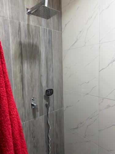 a shower with a red towel and a phone in a bathroom at Velipoja Guest House 1 in Velipojë
