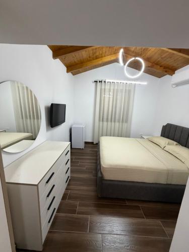 a bedroom with a bed and a mirror at Velipoja Guest House 1 in Velipojë
