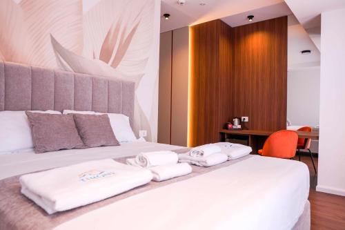 a bedroom with a white bed with towels on it at Tirone Luxury Rooms in Cirò Marina
