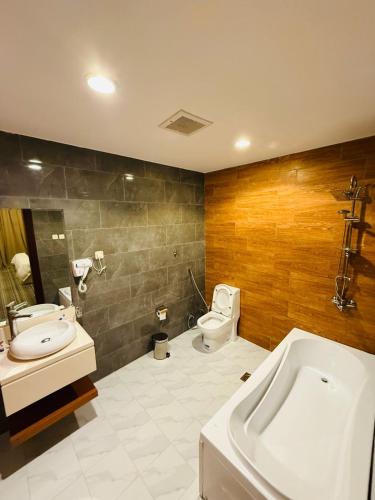 a bathroom with a toilet and a sink and a tub at نزل خيال جيزان in Jazan