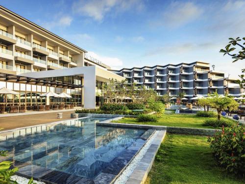 an exterior view of a hotel with a swimming pool at Novotel Phu Quoc Resort in Phú Quốc