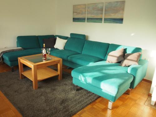 a living room with a blue couch and a table at Ferienwohnung Austernfischer Ockholm in Ockholm