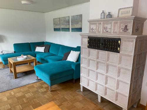 a living room with a blue couch and a table at Ferienwohnung Austernfischer Ockholm in Ockholm