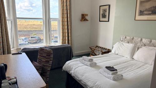 a hotel room with a bed and a table and a window at The Sandpiper in Barmouth