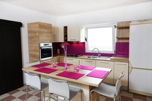 una cucina con tavolo in legno e tappetini rosa di Modern apartment near Split center a Spalato (Split)