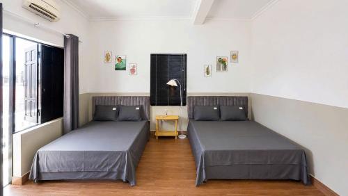 a room with two beds and a window at LaBo Homestay in Quan Lạn