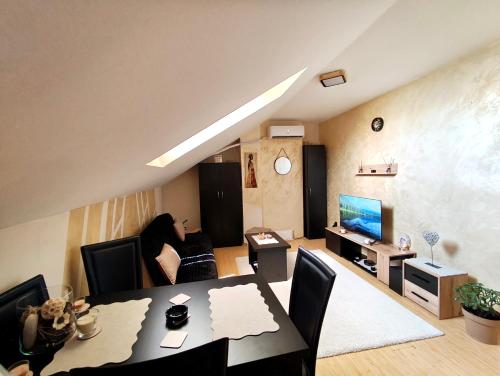 a woman sitting at a table in a living room at Nebeski kutak in Valjevo