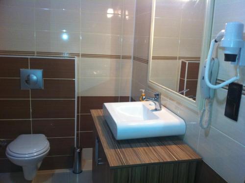 uma casa de banho com um lavatório e um WC em TJ's Hotel em Eceabat