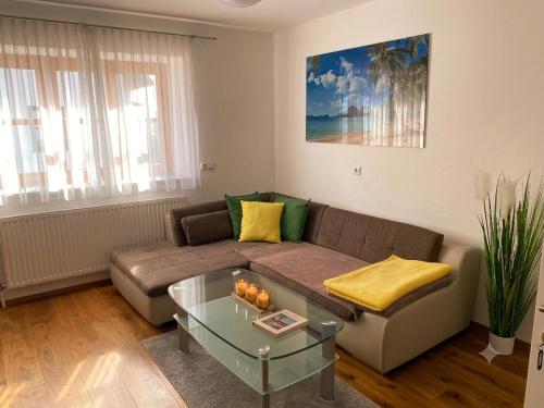a living room with a couch and a glass table at Wohnen im Grünen - Landidylle mit Komfort Nähe Linz in Pregarten